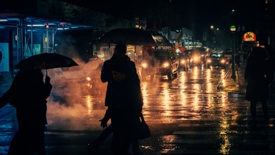 Rainy night holding an umbrella person's silhouette
